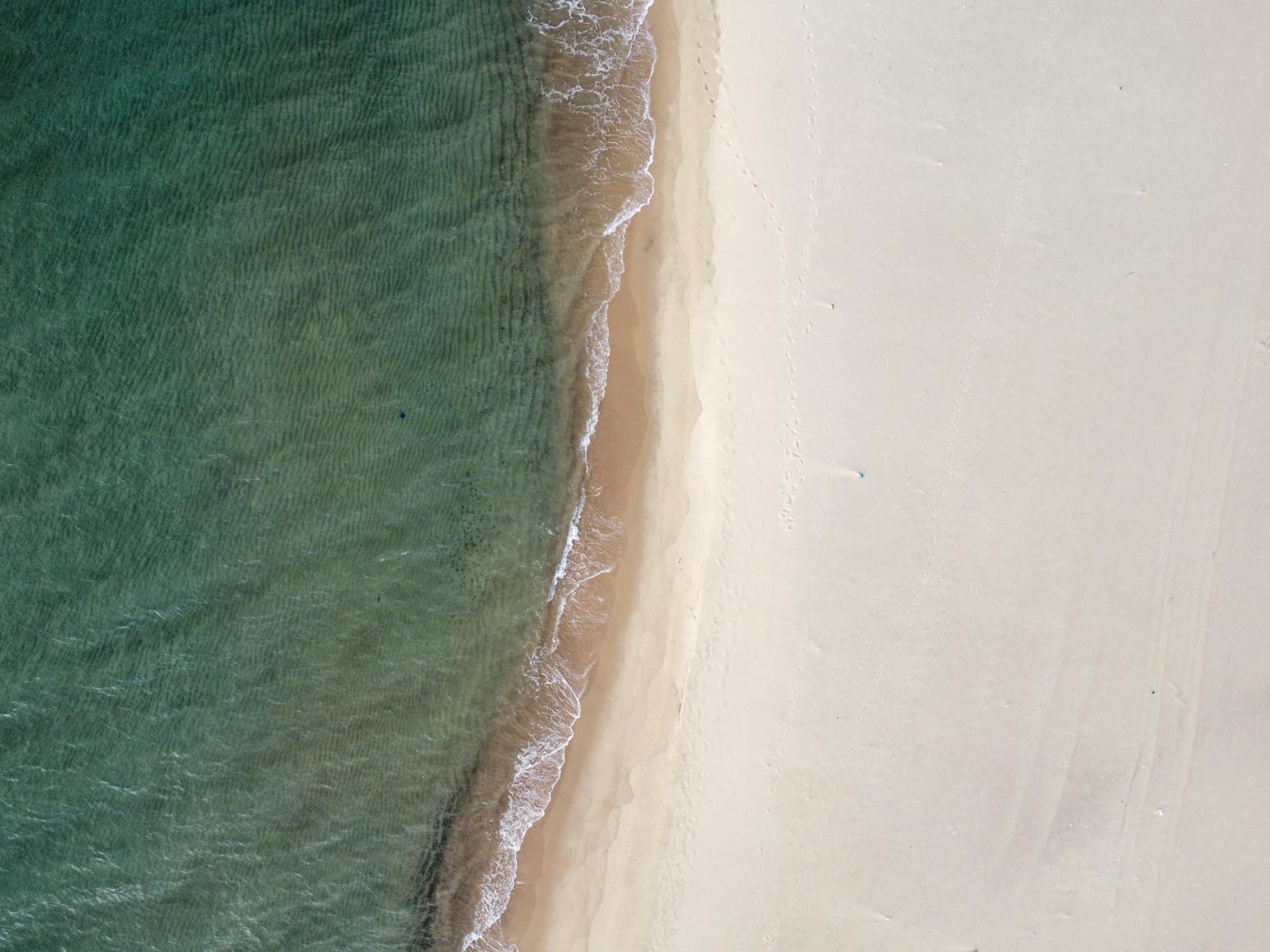 A stunning aerial shot of a serene beach with turquoise waves in Nefza, Tunisia.