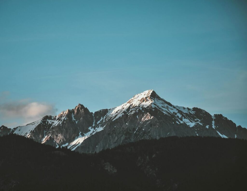 Stunning view of snow-capped mountains against a blue sky, perfect for nature lovers.